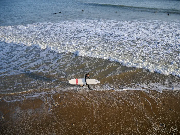 Surfeur marchant avec sa planche sous le bras à Jard-sur-Mer